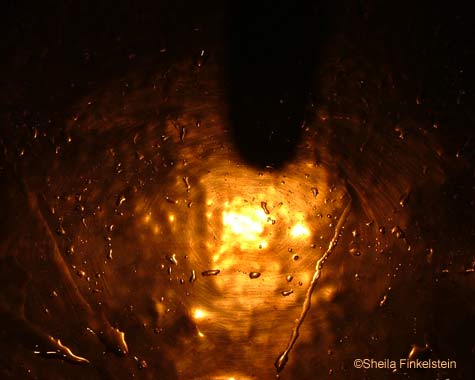 light reflected in bronze sink at Cheesecake Factory