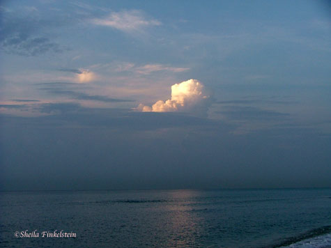 Sun behind a puffy cloud at Delray Beach